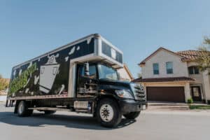 Square Cow Movers truck parked on a residential street in front of a house