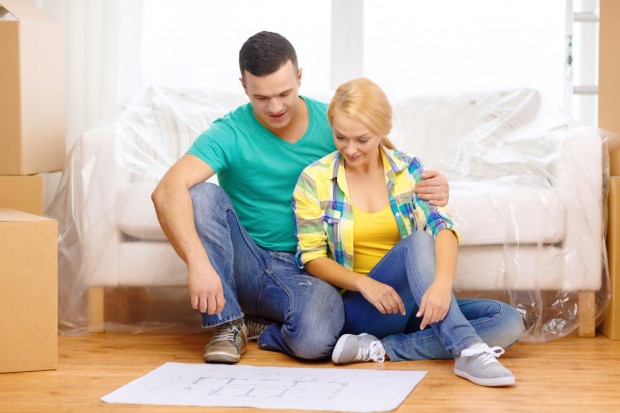 smiling couple looking at bluepring in new home