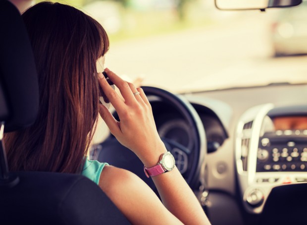 woman using phone while driving the car