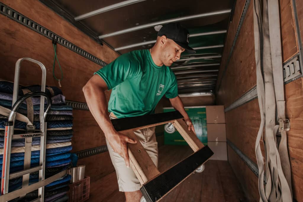 Moving crew loading furniture inside moving truck