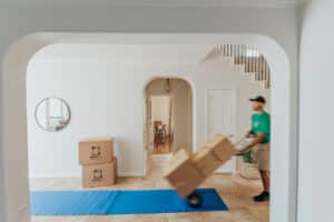 Professional movers transporting and packing boxes inside a bright, modern home