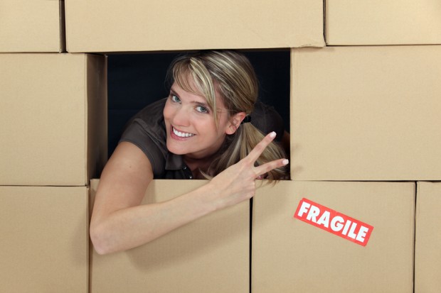 Woman in a wall of cardboard boxes