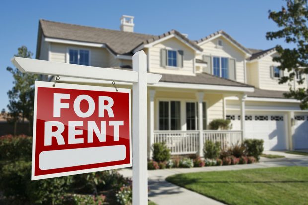 Right Facing Red For Rent Real Estate Sign in Front of Beautiful