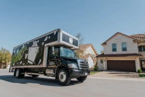 Moving truck parked on a residential street in front of a suburban home