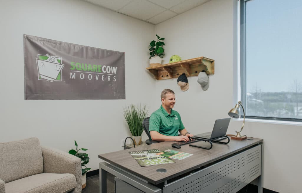 Square Cow Movers employee working at a desk in a branded office space