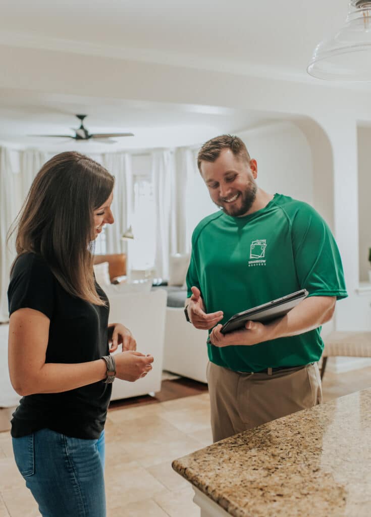 Mover showing a customer details on a tablet in a bright kitchen