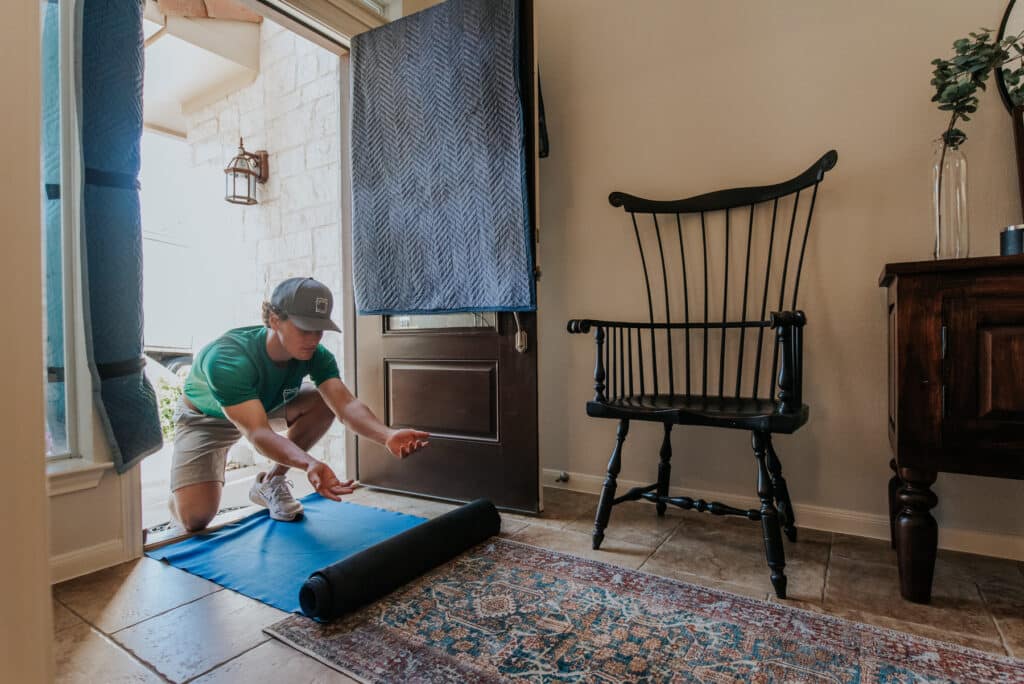 A man in a green shirt kneels on a mat
