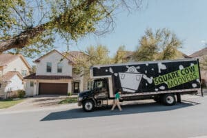 A man stands in front of a moving truck