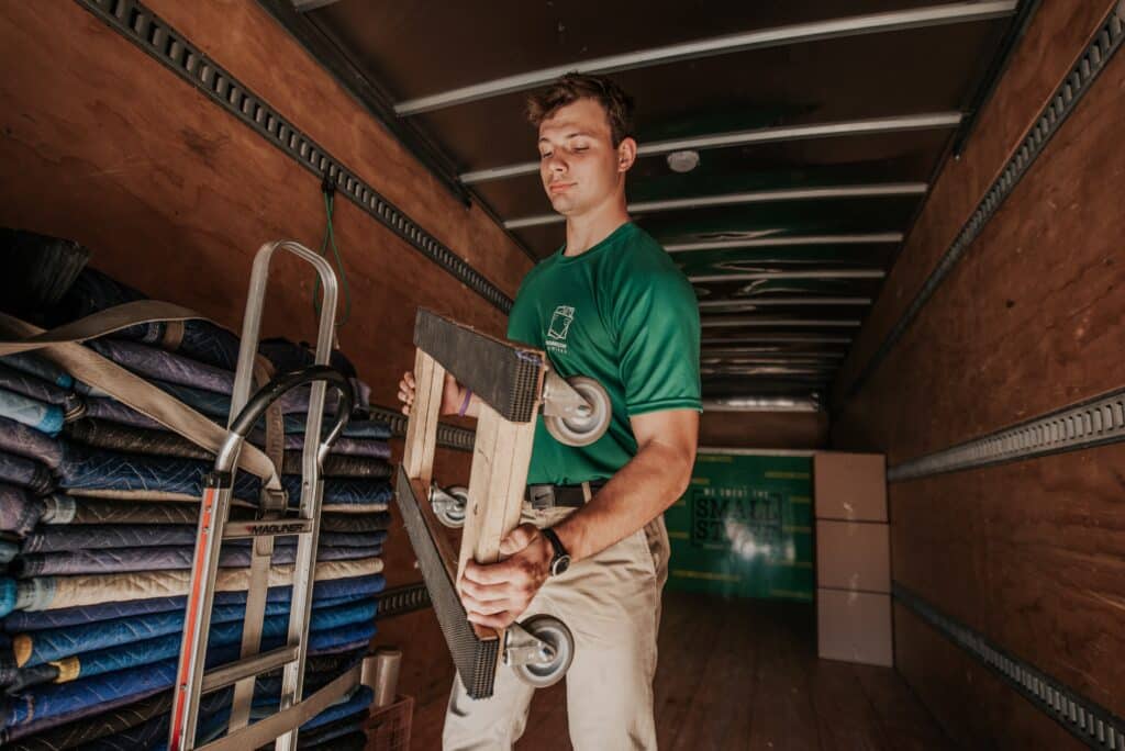 Mover carrying a dolly with wheels inside a truck.