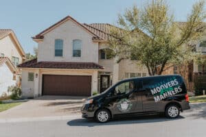 A Square Cow Movers van is parked in front of a residential house.
