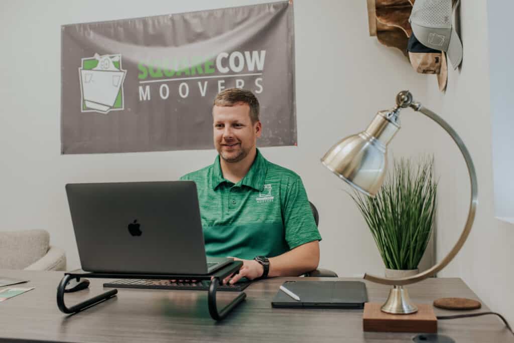 Square Cow Movers employee working at a desk with laptop