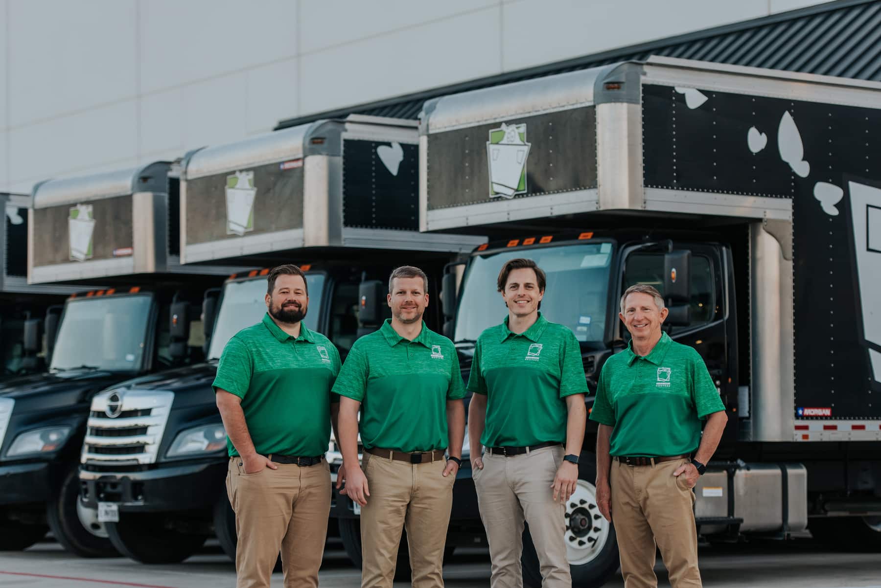 Square Cow Movers team standing in front of moving trucks