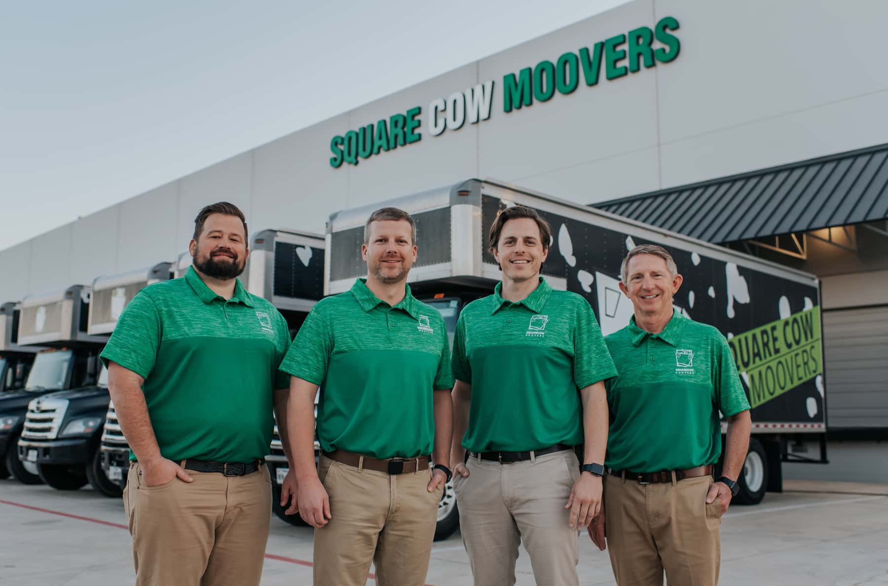 Square Cow Movers team standing in front of moving trucks