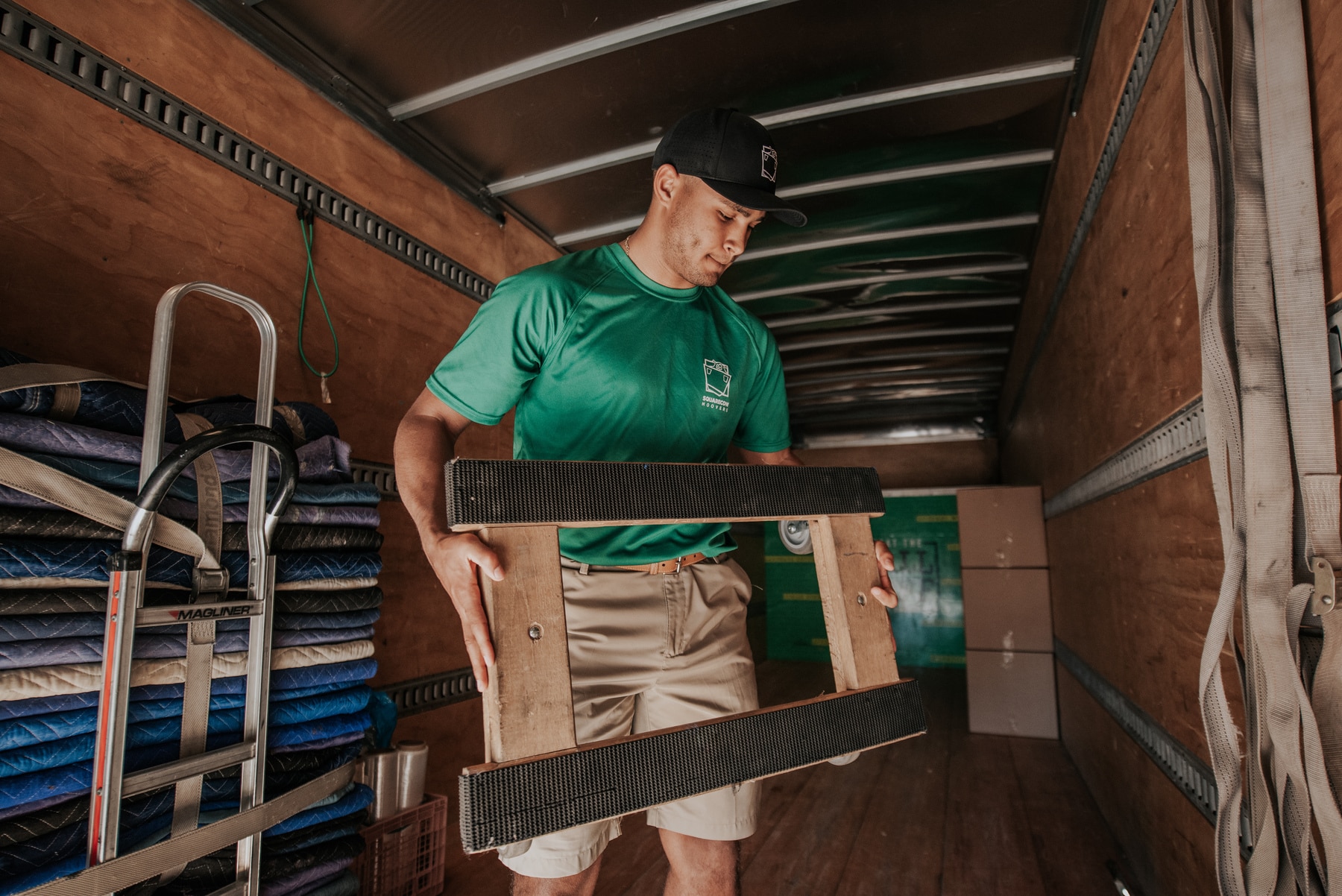 Mover loading furniture dolly into moving truck