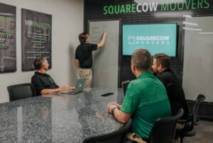 Square Cow Movers team reviewing moving operations during an office meeting