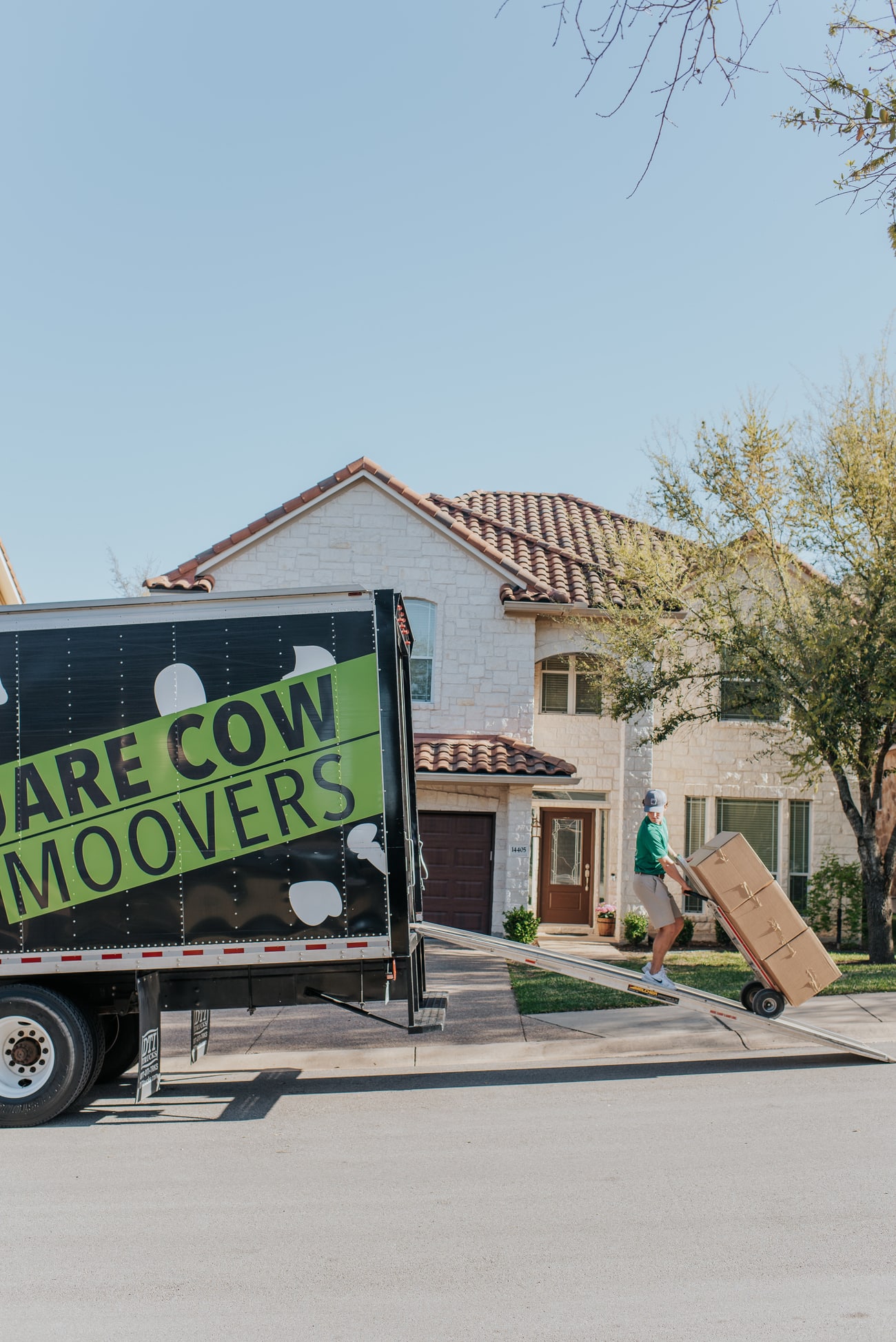 Square Cow Movers crew member loading a furniture dolly into a moving truck