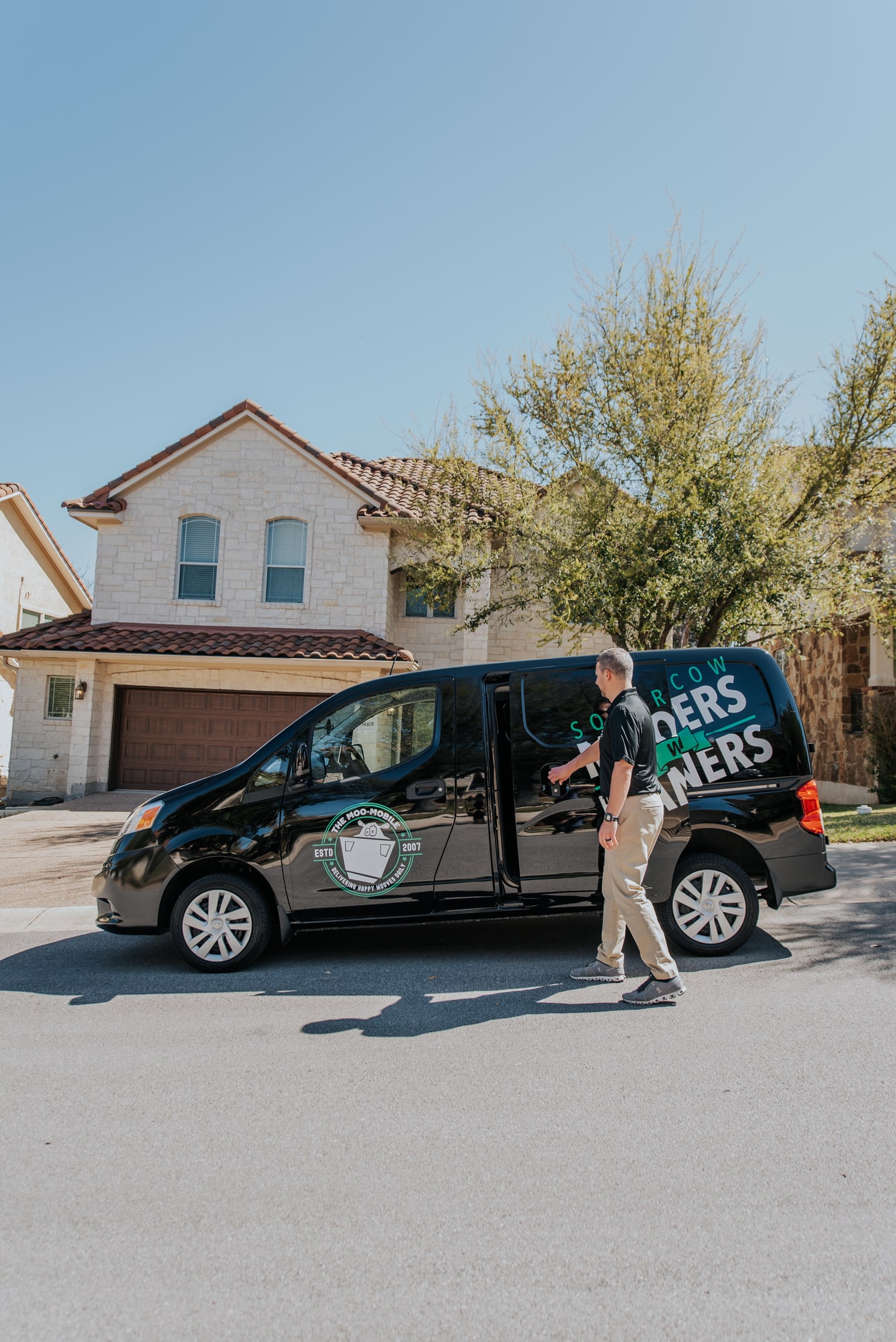 Square Cow Movers team member arriving at a customer's home in a branded moving van