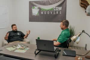 Square Cow Movers team discussing moving plans during an office meeting