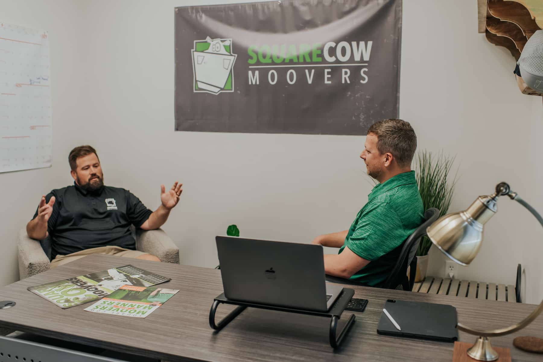 Square Cow Movers team discussing moving plans during an office meeting