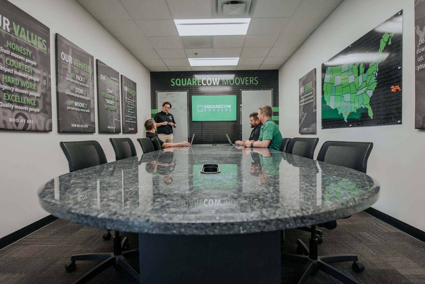 Square Cow Movers staff meeting in the conference room with a presentation