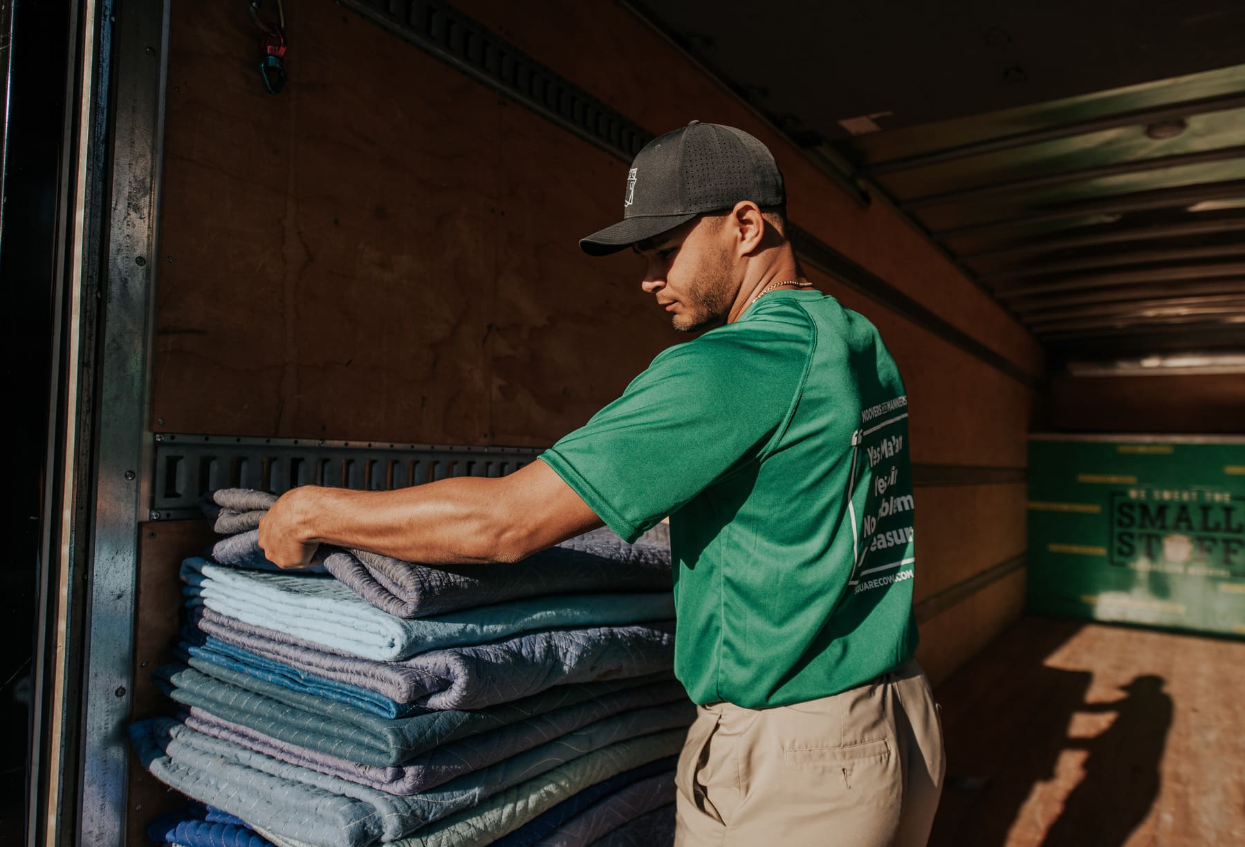 Square Cow mover stacking protective blankets inside a truck