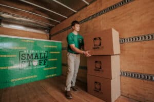 Mover stacking cardboard boxes inside a moving truck