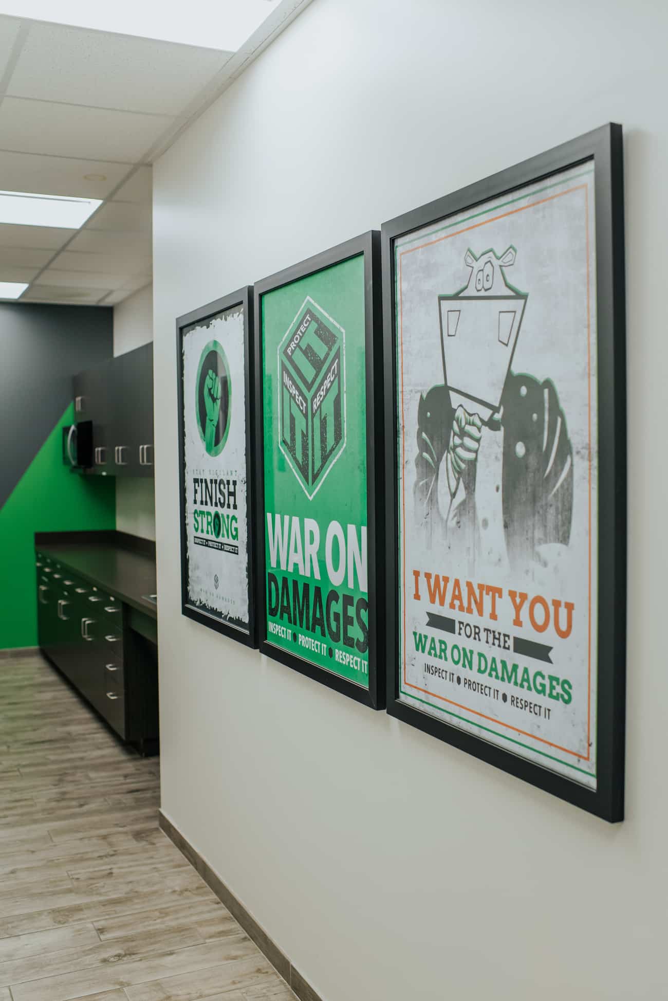 Framed Square Cow Movers posters displayed in an office hallway