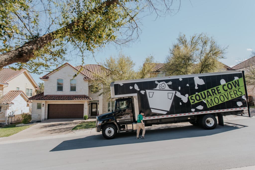 Square Cow Movers truck parked outside a home
